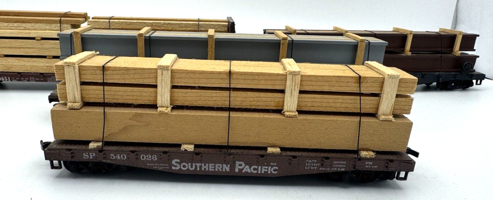 LOT OF 4 DIFFERENT HO GAUGE MODEL RAILROAD S P WOOD CARRIER CARS WITH LOADS